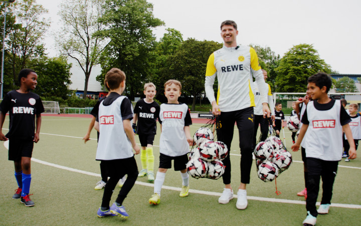 Gregor Kobel (BVB) mit einer Jugendmannschaft auf dem Spielfeld.